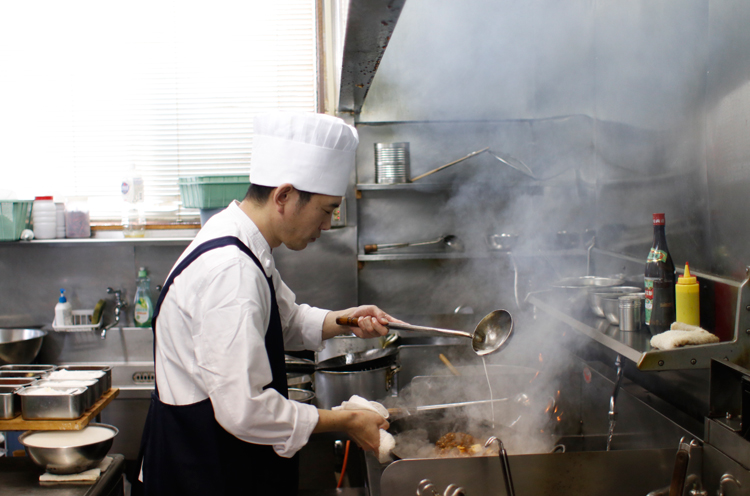 さまざまな調味料を使い分け、手際よく料理をする店主の中村さん