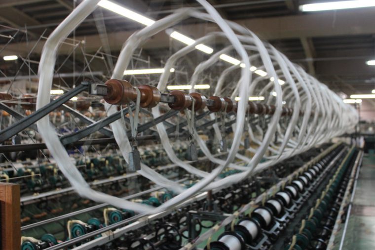仕入れた高品質の絹糸を織物に加工するためボビンに巻き付ける作業。工場内には糸をまくカランカランという音が鳴り響きます