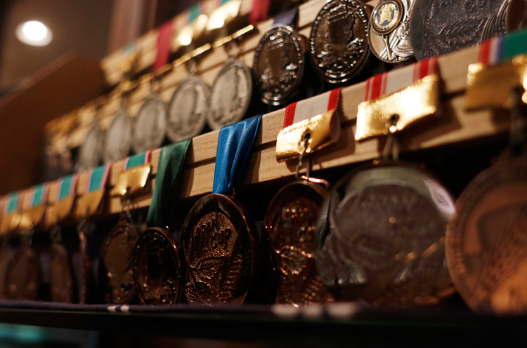 キラキラのメダルや盾がずらりと展示されています
