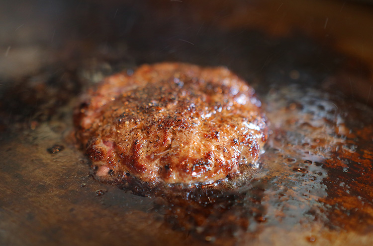 コショウがきいた粗挽きの肉を 鉄板で丁寧に焼き上げる。