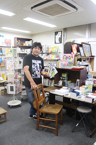 店主・佐藤雄一さん。店内のRYUTistコーナーで撮影。RYUTisメンバー、ファンにも愛される店主さんです