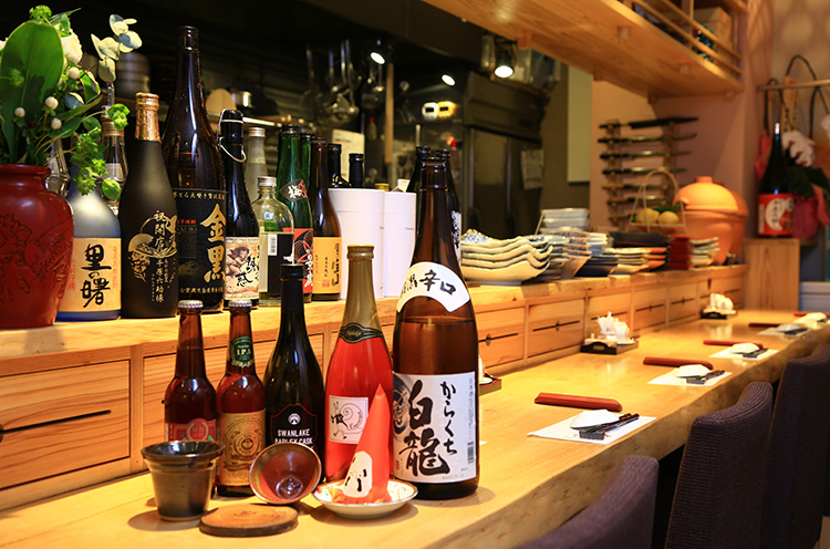 スワンレイクビール、白龍酒造の日本酒、酒器まで阿賀野市産。お通しの三角だるまはあけてからのお楽しみ