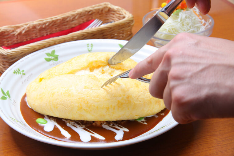 ライスの上にのったオムレツにそっとナイフを入れると、半熟卵がとろりとあふれ出します！