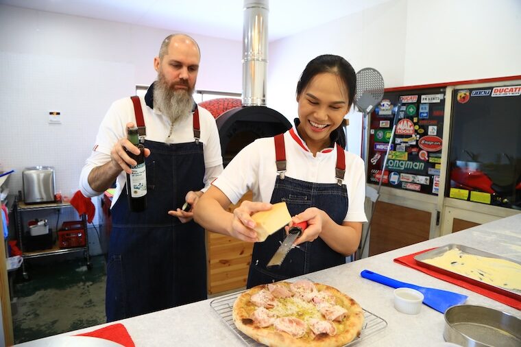 楽しそうにピザを作るミケーレさん（写真左）とプイさん（写真右）