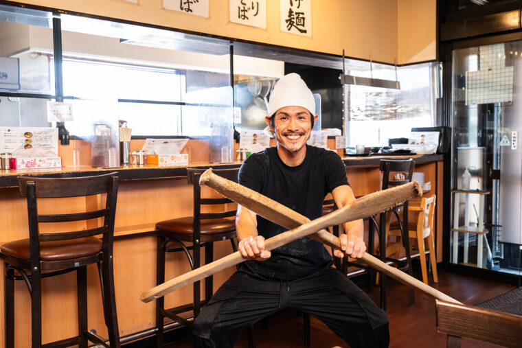 店主の廣橋春夫さん。手に持っているのが煮干しを砕く際に欠かせないエンマ棒