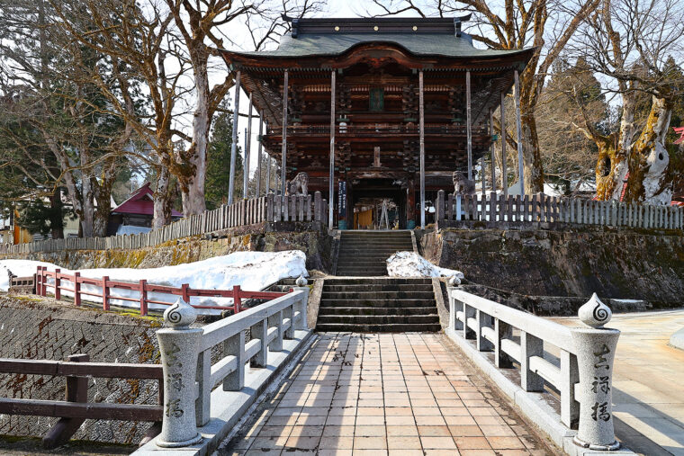 JR浦佐駅から徒歩5分。回廊の先にある不動明王の石仏像も必見