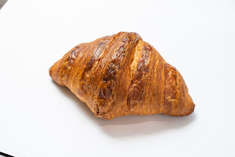 『クロワッサン』（280円）。塚田バターを折り込んだ、ほどよい甘さのクロワッサン。大きめサイズとサックリ食感が特徴