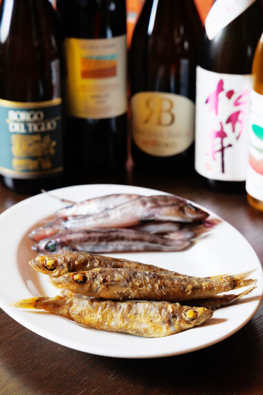 常磐で水揚げされた『メヒカリ』 （5 尾2,100 円〜）を唐揚げに。 くさみの一切ない風味と身のやわらかさに感動。種類豊富に揃うイタリア産の白ワインや、ふくよかな米のうまみが感じられる純米酒と味わいたい