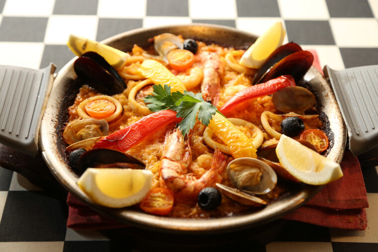 一番人気の『海の幸のパエリア』（写真は2人前）。たっぷりの魚介に加え、アサリのうまみが詰まったスープがおいしさのポイント。1 人前1,628円（注文は2人前～）
