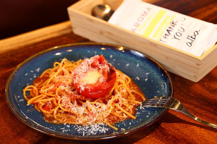 『丸ごとトマトとモッツァレラチーズのパスタ』（1,340 円）。スタッフがひとつひとつメッセージを手書きしたおしぼりにも注目