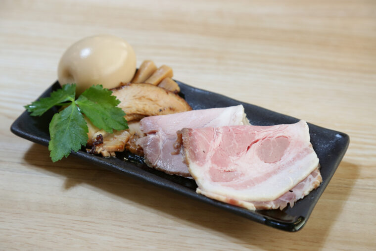 『特製つけめん・並』（1,700 円）の注文時には、国産豚を低温調理した3種のチャーシューを別添えで提供