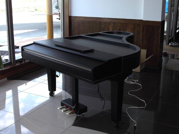 グランドピアノみたいだけど、これはお菓子を並べる展示台。福島県南相馬市の菓子店から依頼されて製作した。鍵盤部分は電子ピアノで演奏!