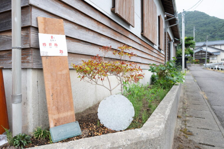入口は建物裏手。この看板を目印に