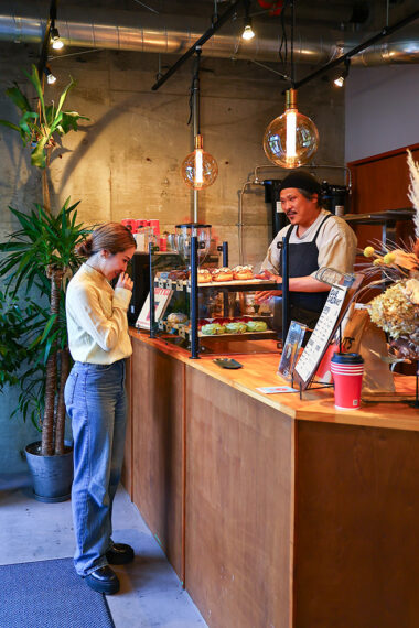 ショーケースを眺めるすみれさんと店主の岩村さん