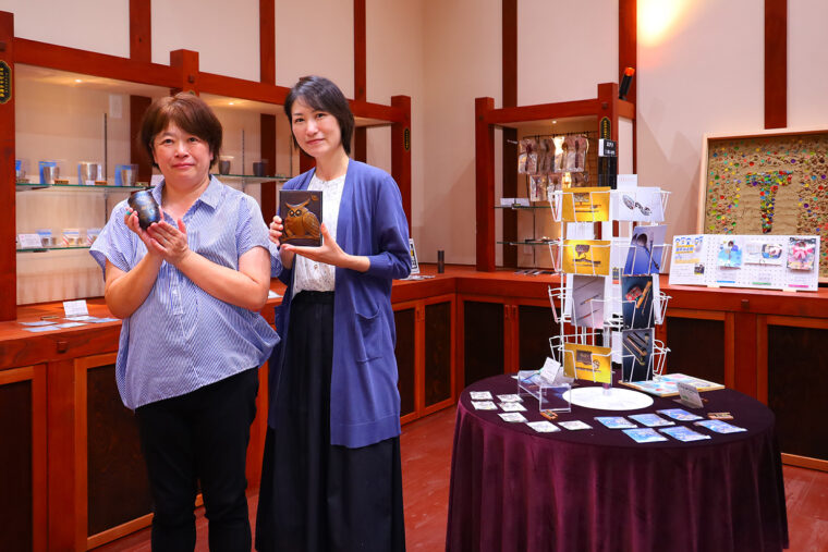 「オリジナル商品や企画展にゆかりある商品が揃っています」と副館長の阿部麻紀さん（左）