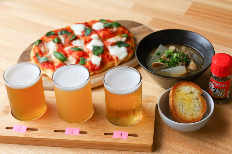『飲み比べ3種』（1,400 円）、『もつ煮』（600円）、『マルゲリータPIZZA』（1,100円）
