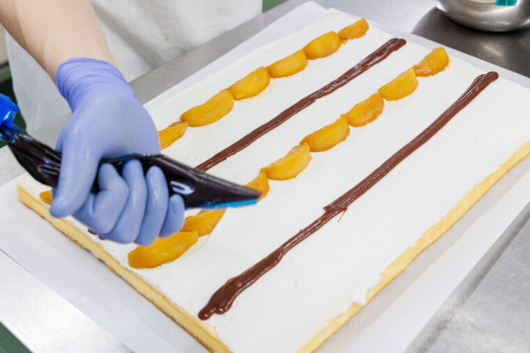 リンゴのキャラメルソテーとキャラメルソースをロール生地にのせて…