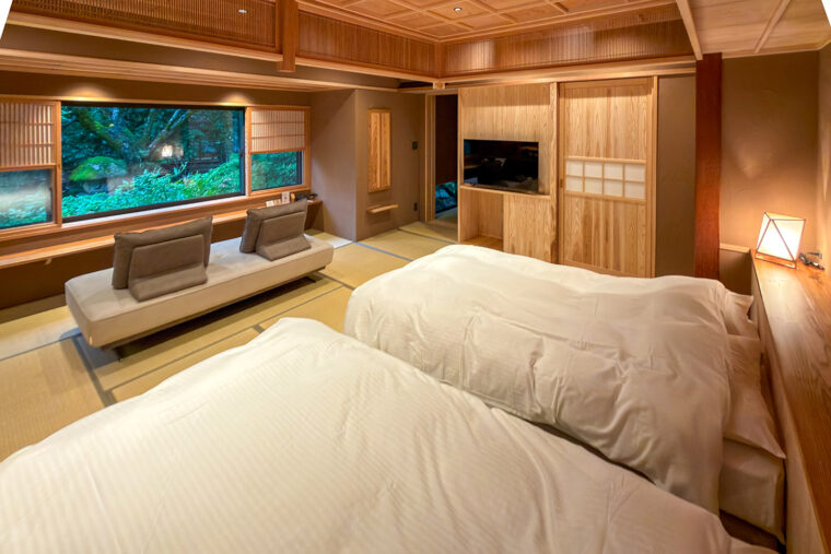 温泉付ベッド客室離れ・和みの昭和の間。ベッドからもソファからも庭を眺められる