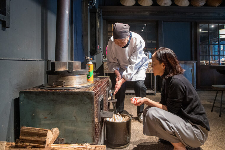 かまどの火を絶やさないように次から次へと薪をくべる