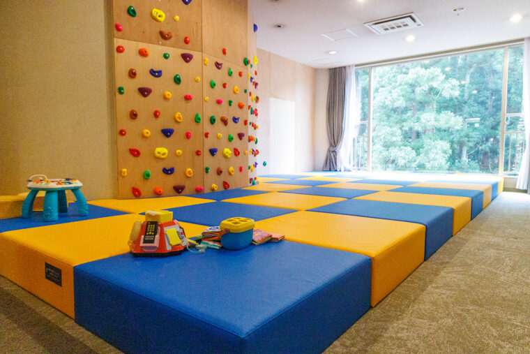 安心・安全に配慮したキッズルーム。絵本やおもちゃを多数用意するほか、手や足をかけて壁を登るボルダリングウォールも設置