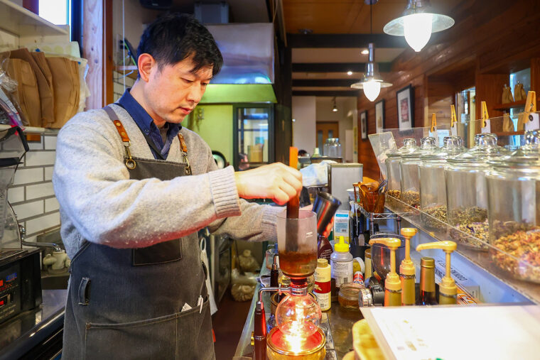 サイフォンでコーヒーをいれる店主の坂井さん