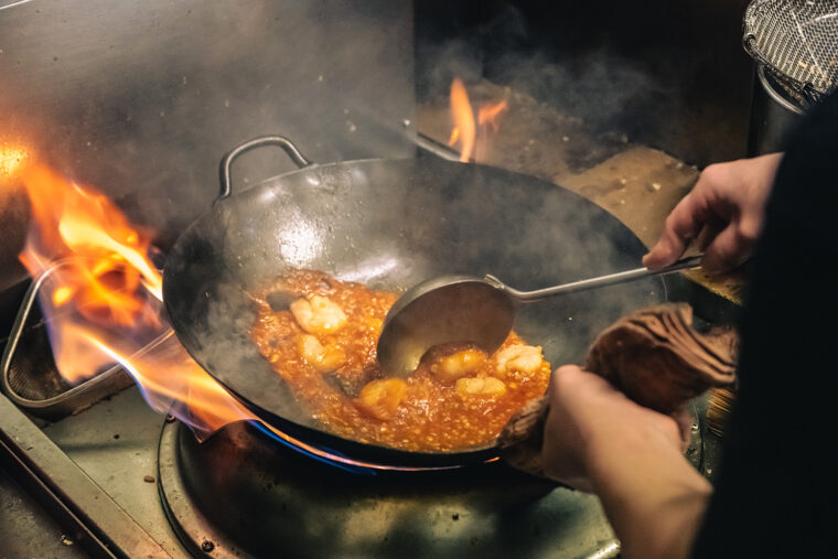 強火で一気に炒め、迷いなく皿を仕上げていく姿につい見入ってしまいます。