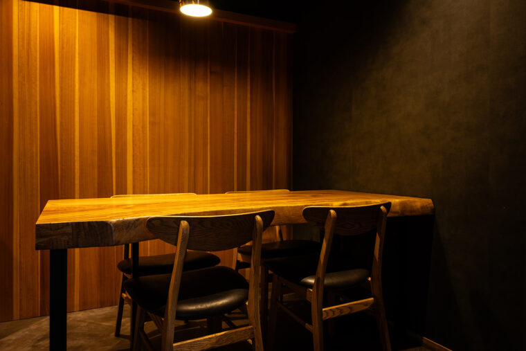 テーブル席も用意。立派なクスの木の一枚板が料理を引き立てる