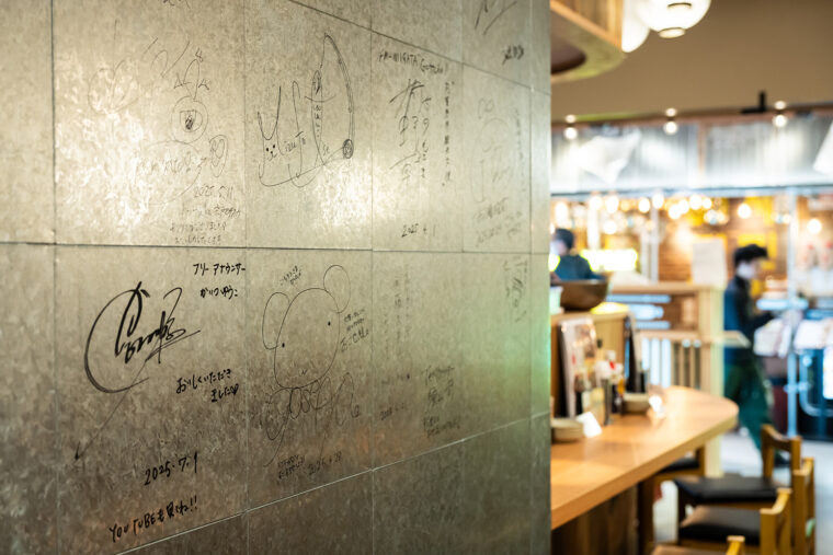 店内壁には県内外から訪れた著名人のサインが書かれている