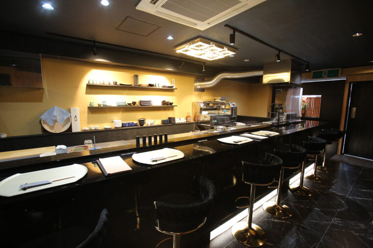 ブラックで統一された高級感あるカウンター席。目の前では真剣な調理が繰り広げられる