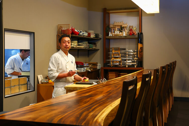 店主の小山誠さん。 一枚板のカウンターも自慢です。なお平日のみ昼営業を実施。予約も受け付けています