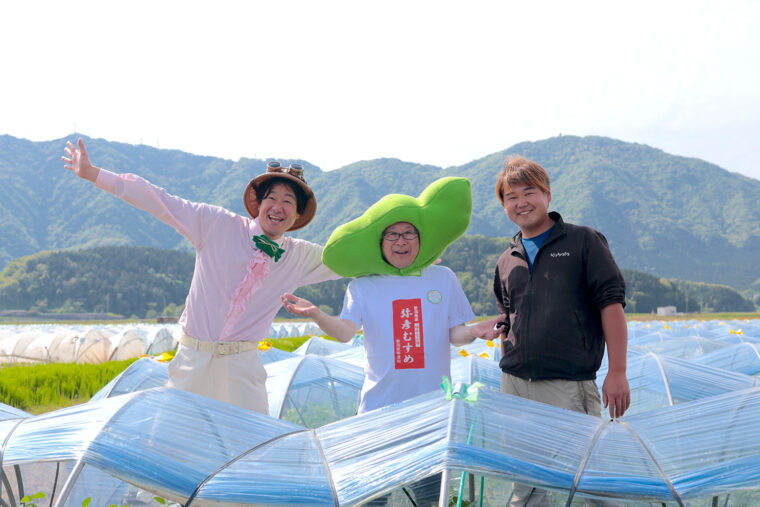 弥彦山をバックに枝豆生産者の丸山雄太郎さんと記念撮影