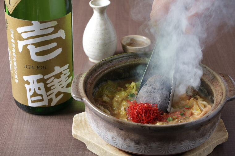 熱く焼けた石を豪快に放り込む名物の火山煮込み