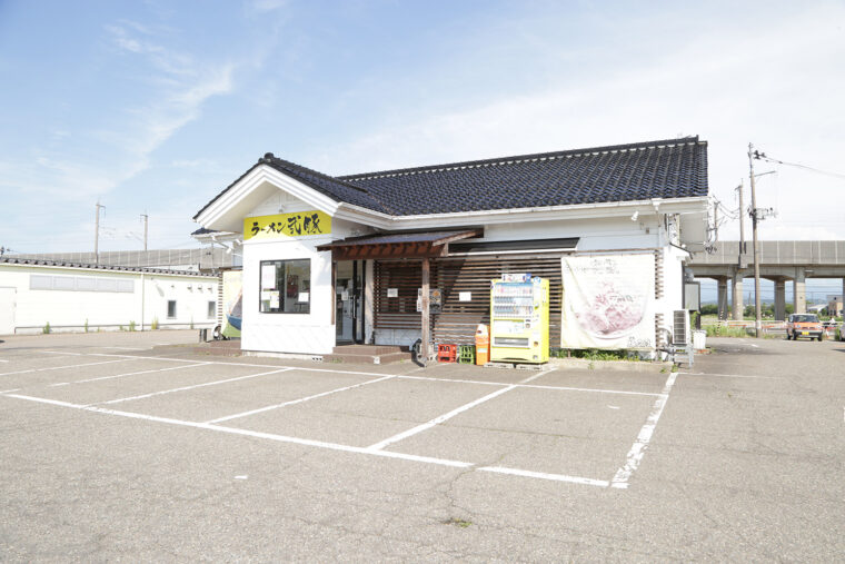 国道8号沿いに位置する。ひと際目を引く黄色い看板が目印