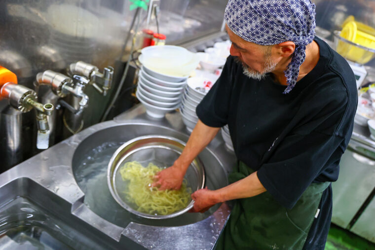うまみを逃さぬよう、茹でた麺を氷水で一気 に締める店主の細貝さん