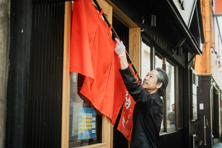 オーナーの齋藤雄司さん。のれんを掲げ、今日も多くのお客を迎える準備は万端